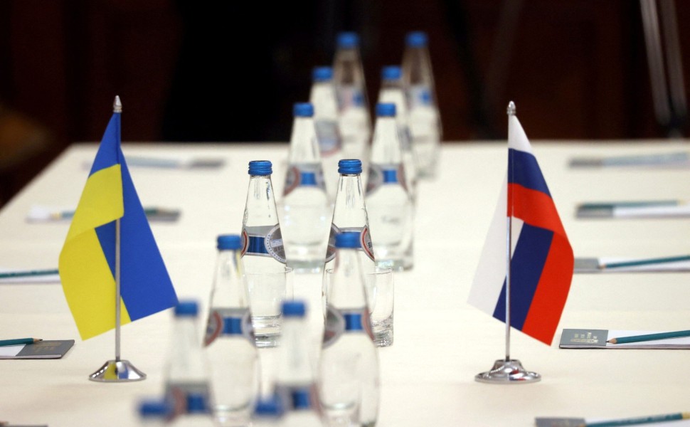 Russian and Ukrainian flags are seen on a table before the talks between officials of the two countries in the Gomel region, Belarus February 28, 2022.  Sergei Kholodilin/BelTA/Handout via REUTERS