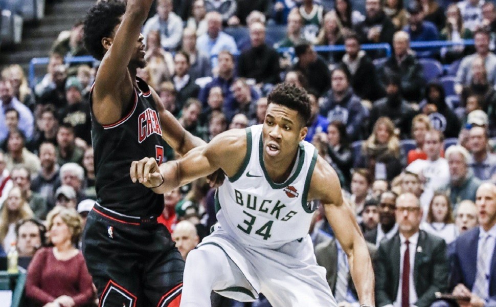 epa06406432 Milwaukee Bucks forward Giannis Antetokounmpo of Greece (R) steps out of bounds while being guarded by Chicago Bulls guard Justin Holiday (L) in the first half of their NBA game at the BMO Harris Bradley Center in Milwaukee, Wisconsin, USA, 26