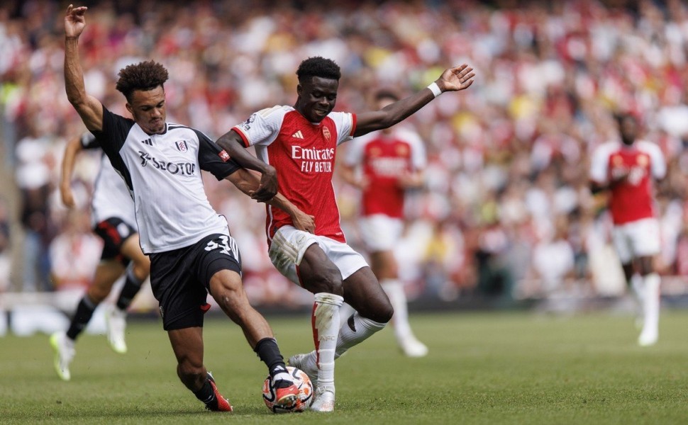 epa10821935 Bukayo Saka of Arsenal in action against Antonee Robinson of Fulham during the English Premier League match between Arsenal London and Fulham FC in London, Britain, 26 August 2023.  EPA/TOLGA AKMEN EDITORIAL USE ONLY. No use with unauthorized 