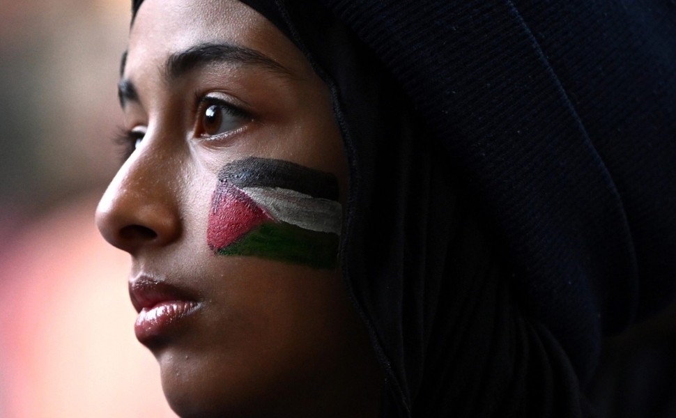 epa10910756 A woman with a Palestinian flag painted on her face takes part in a rally against the occupation of Palestinian territories and the conflict between Israel and Hamas, at State Library of Victoria, in Melbourne, Australia, 10 October 2023. More