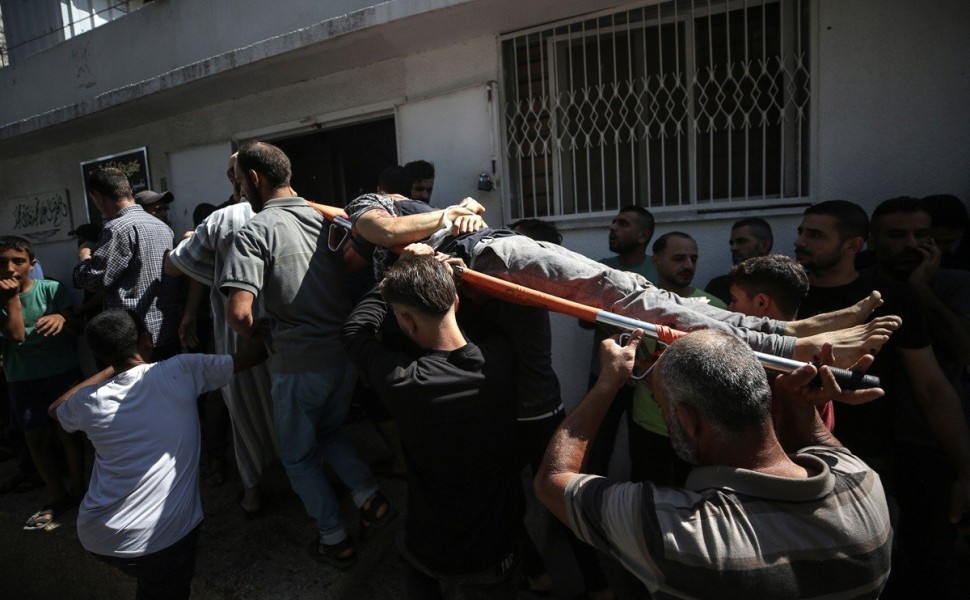 epa10905346 Palestinians carry the body of a fighter killed during the storming of Israel settlements by militants of the Ezz Al-Din Al Qassam militia, the military wing of Hamas movement, in Al-Shifa hospital in Gaza City, 07 October 2023. Rocket barrage