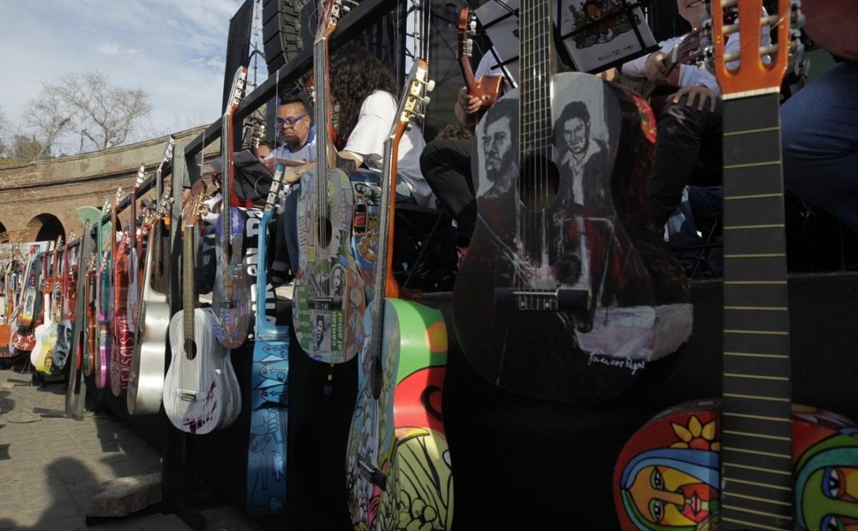 epa10870823 Musicians and attendees play guitars during an event in honor of Víctor Jara in Santiago, Chile, 19 September 2023. During the event, tribute was paid to the singer-songwriter who was tortured and murdered by the dictatorship of Augusto Pinoch