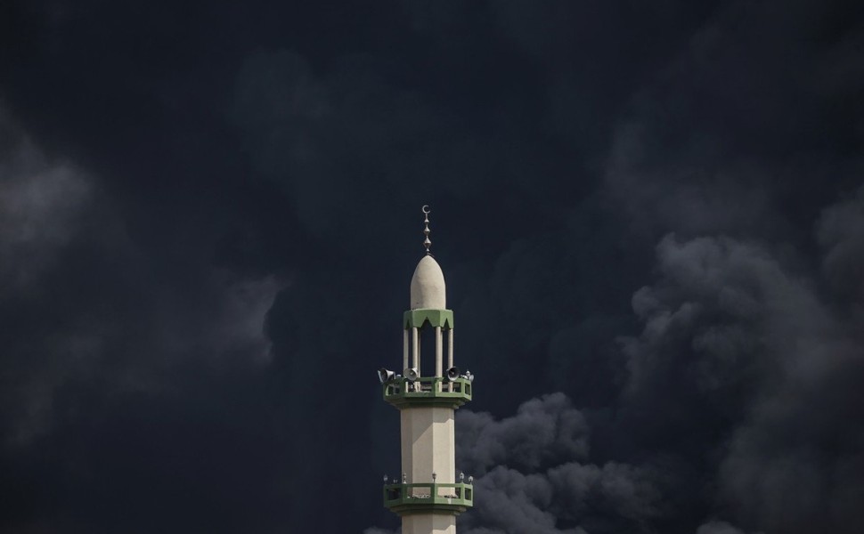 epaselect epa10913597 Smoke rises behind a minaret following an Israeli air strike on the Al-Tufah neighborhood, Gaza City, 11 October 2023. More than 1,000 Palestinians have been killed and over 5,000 others injured, according to the Palestinian Ministry