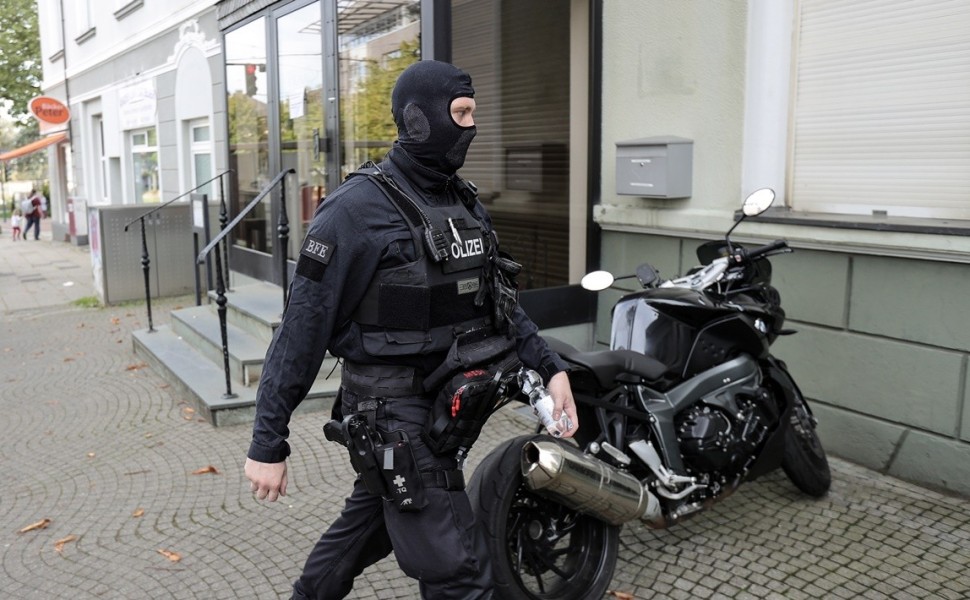 epa10885634 A police officer walks during a raid at the practice and flat of Gerhard H., a doctor and suspected member of the 'Artgemeinschaft' far-right group in Essen, Germany, 27 September 2023. German Interior Minister Nancy Faeser on 27 September ann
