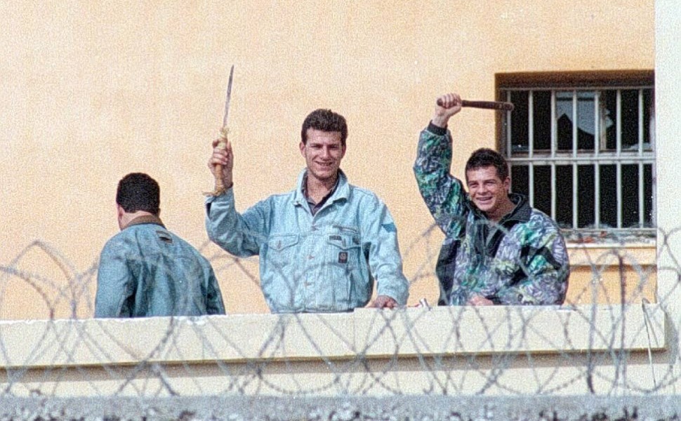 Κρατούμενοι κραδαίνουν μαχαίρια που έχουν αρπάξεις από τη λεηλασία του μαγειρείου κατά τη διάρκεια της εξέγερσης στις φυλακές Κορυδαλλού το 1995 / Eurokinissi