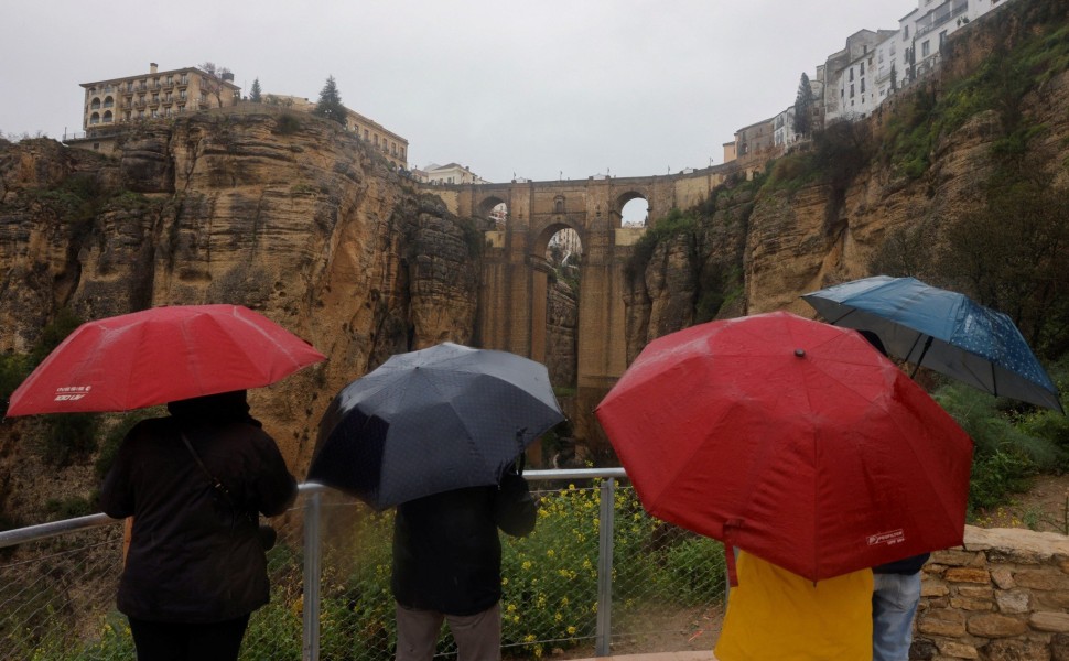 Τουρίστες με ομπρέλες στην Ρόντα / Reuters