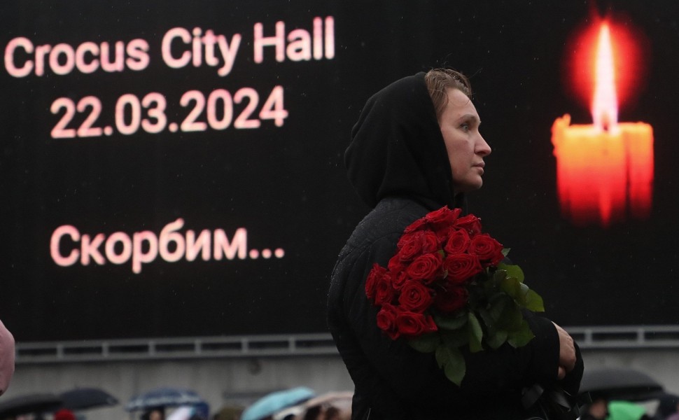 Εικόνα από ανθρώπους που θρηνούν και αφήνουν λουλούδια στον συναυλιακό χώρο Crocus City Hall μετά από την τρομοκρατική επίθεση (φωτο: ΑΠΕ-ΜΠΕ/EPA/MAXIM SHIPENKOV)
