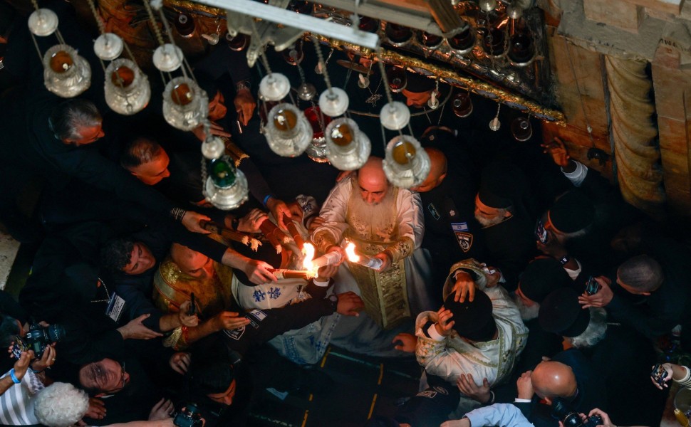 Ο Πατριάρχης Θεόφιλος βγαίνει με το Άγιο Φως από τον Πανάγιο Τάφο / Reuters