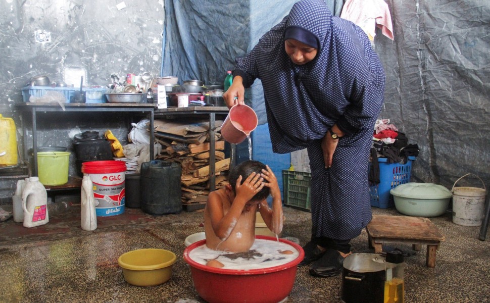 Η Φατίμα πλένει το παιδί της με το νερό που πριν έχει χρησιμοποιήσει για να πλύνει τα πιάτα / REUTERS