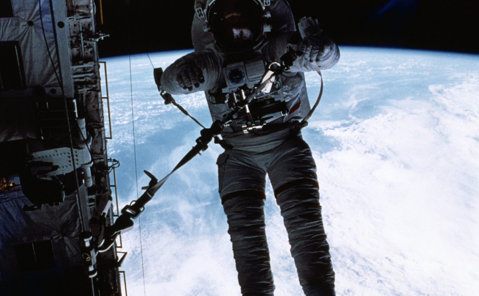 Earth Orbit: Astronaut F. Story Musgrave, STS-6 mission specialist, runs a rope through a snatch block device at the aft bulkhead of the Earth-orbiting Space Shuttle Challenger (Credit: Bettmann / Getty Images)