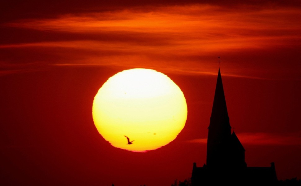 A church is pictured during sunset as a heat wave hits Europe, in Oisy-le-Verger, France, July 14, 2022. REUTERS/Pascal Rossignol